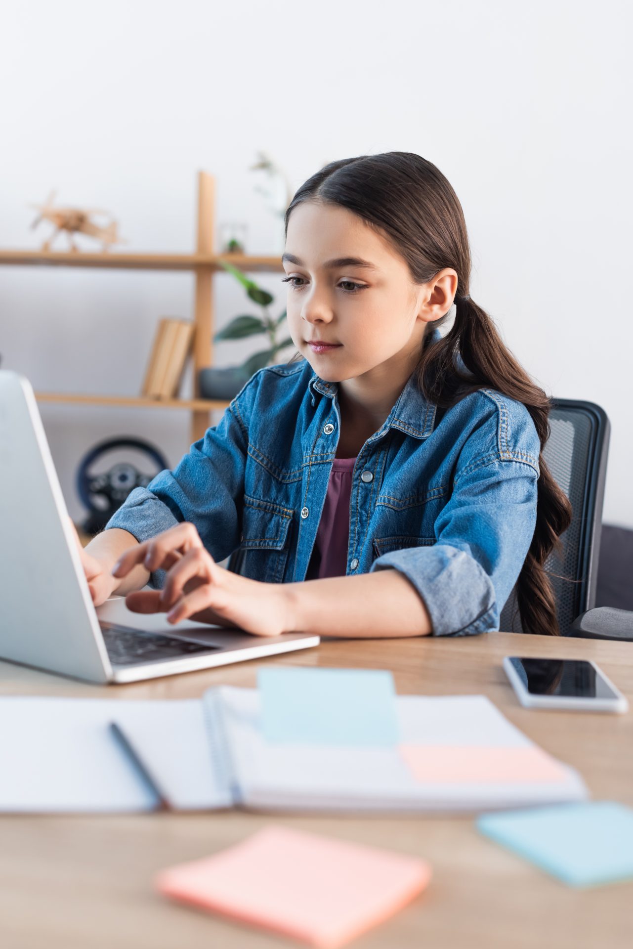 focused-schoolgirl-typing-on-laptop-while-learning-2023-11-27-05-06-15-utc
